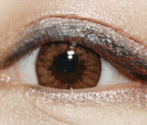 Olens Chandelier Brown — single-eye close-up showing the contact lens appearance