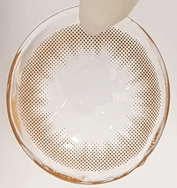 Olens Shining Pure Brown — contact lens held with tweezers