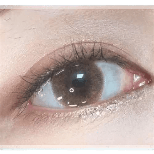 Olens Anna Sui Dolly Girl Tint Brown — single-eye close-up showing the contact lens appearance