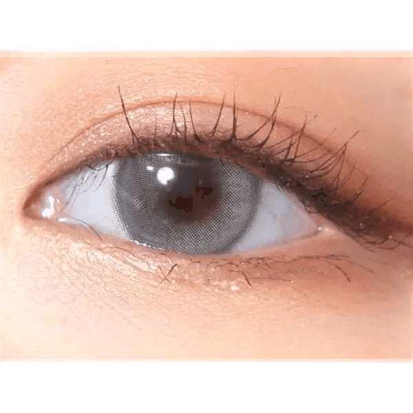 Olens Eyelighter Glowy Ash Gray — single-eye close-up showing the contact lens appearance