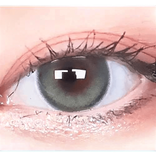 Olens Eyelighter Glowy Ash Gray — single-eye close-up showing the contact lens appearance