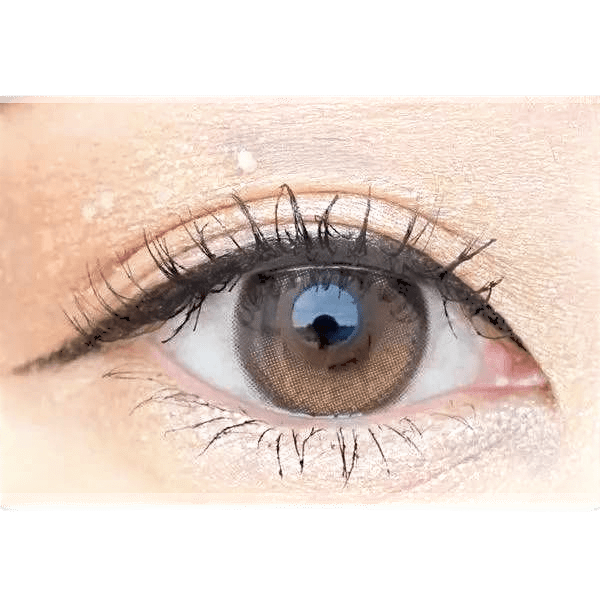 Olens Eyelighter Glowy Brown — single-eye close-up showing the contact lens appearance