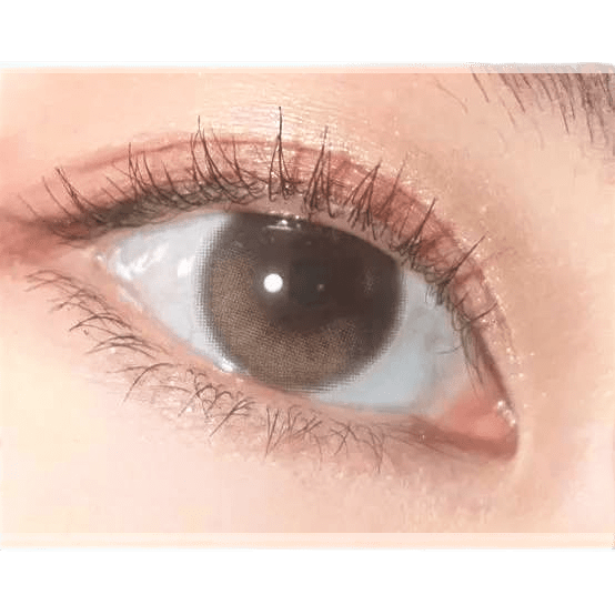 Olens Eyelighter Glowy Brown — single-eye close-up showing the contact lens appearance