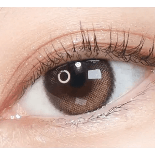 Olens Eyelighter Glowy 1Day Brown (20p) — single-eye close-up showing the contact lens appearance